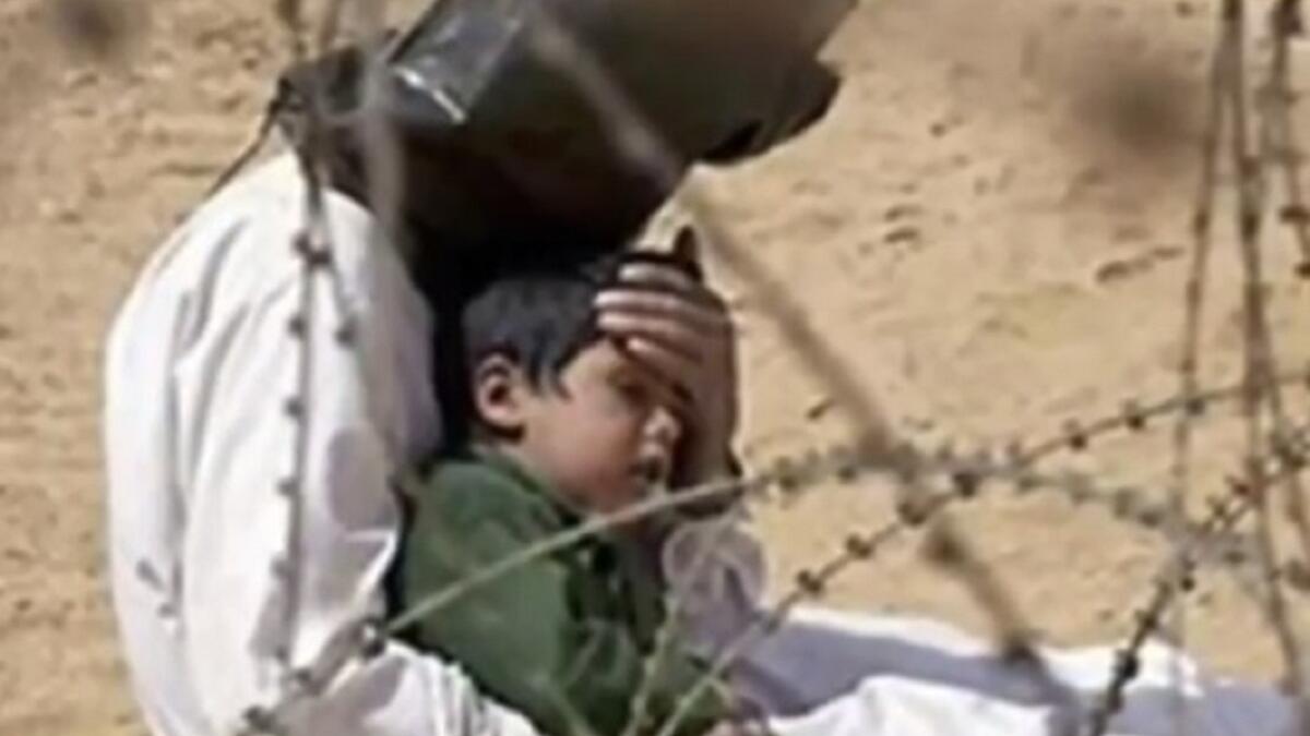 صورة المسجون العراقي الذي حاول حماية طفلة 4 سنوات من حرارة الشمس الحارقة بعدما فك سجانوه قيوده، ولكنهم منعوه من رؤية طفله ووضعوا على رأسه الغطاء .