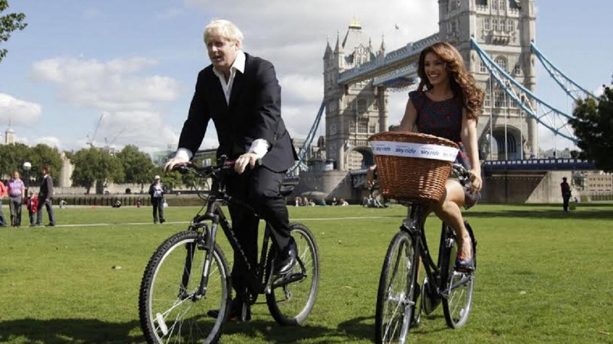 رئيس بلدية لندن السابق بوريس جونسون يركب دراجته برفقة كيلي بروك في لندن، 31 أغسطس/ آب 2010