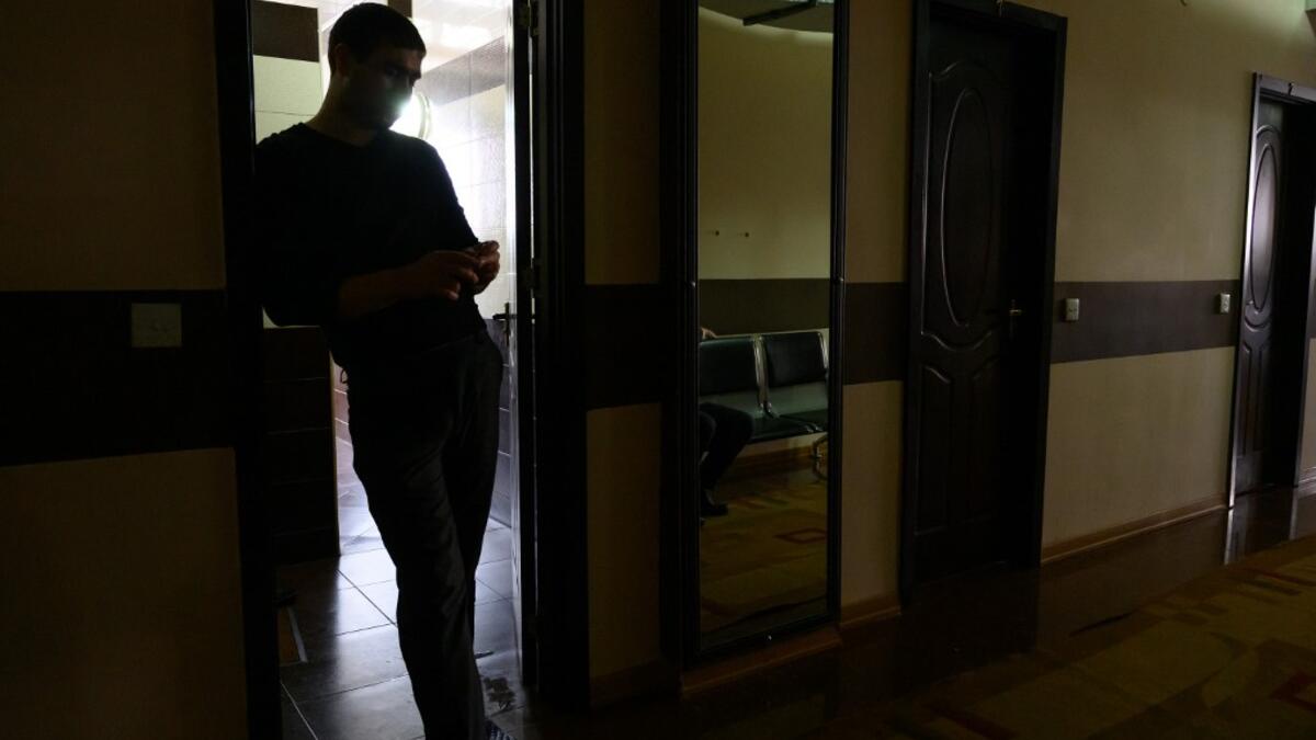 A man stands in a corridor at the Sehirli Naftalan Health Center, some 300 kilometres (186 miles) from capital Baku, on March 21, 2019. Immersed up to her neck in crude oil, a Russian woman suffering from joint disease smiles in delight, confident that the treatment at a spa in northwestern Azerbaijan will cure her painful condition.  Mladen ANTONOV / AFP