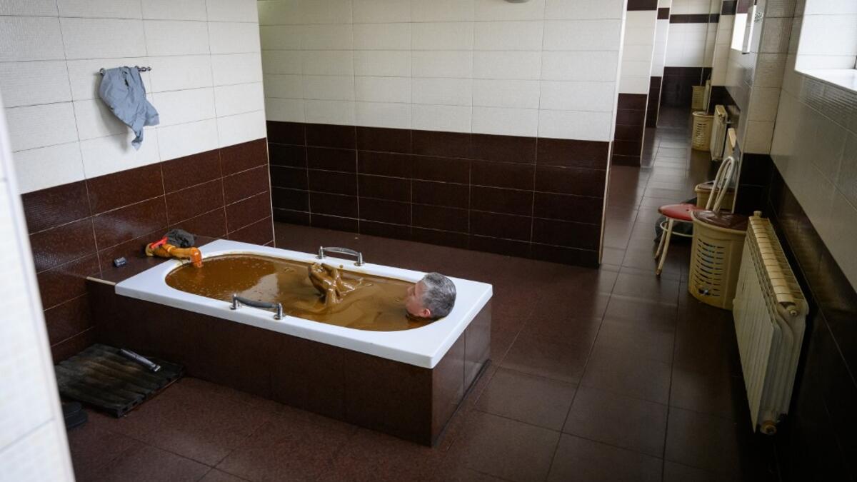 A man bathes in a tub filled with Naftalan crude oil during a treatment session at Sehirli Naftalan Health Center, some 300 kilometres (186 miles) from capital Baku, on March 21, 2019. Immersed up to her neck in crude oil, a Russian woman suffering from joint disease smiles in delight, confident that the treatment at a spa in northwestern Azerbaijan will cure her painful condition.  Mladen ANTONOV / AFP