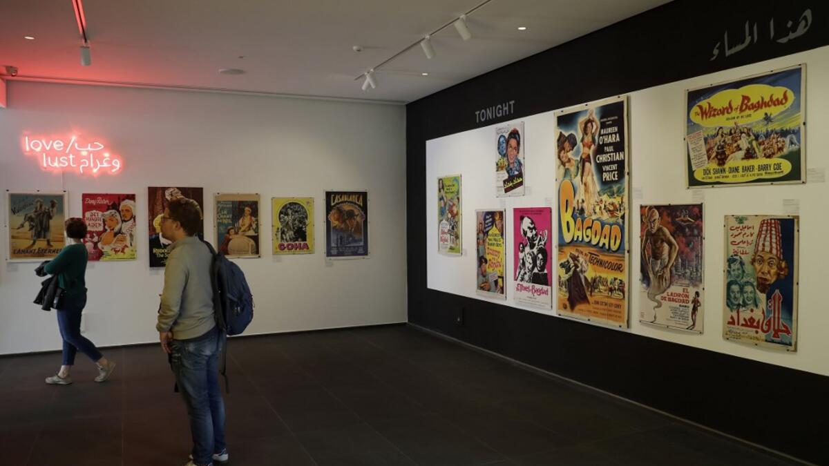 Visitors observe vintage cinema posters displayed at an art exhibition in the Lebanese capital Beirut  JOSEPH EID / AFP