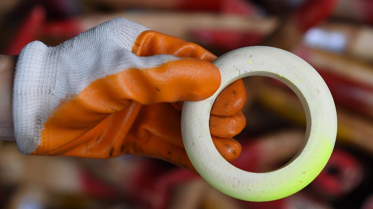 A member of a wildlife personnel team displays a product made from ivory tusks before the confiscated ivory was destroyed at the Kualiti Alam Waste Management centre in Port Dickson on April 30, 2019.  Mohd RASFAN / AFP