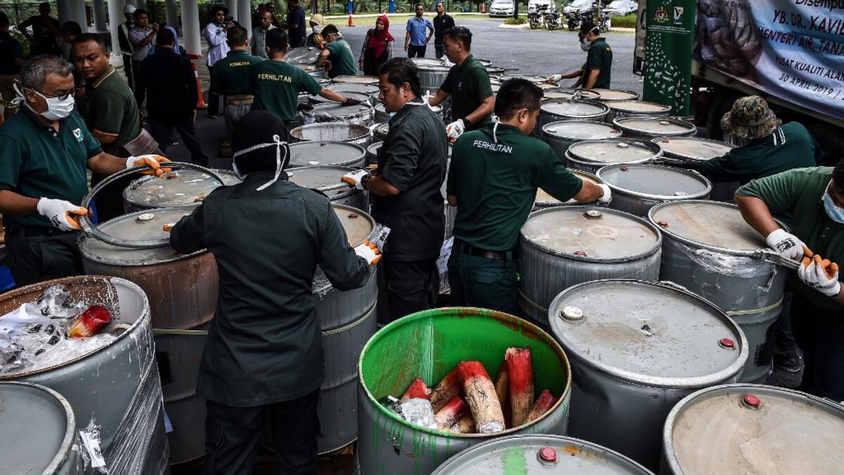 Wildlife personnel open containers of seized ivory tusks before the confiscated ivory was destroyed at the Kualiti Alam Waste Management centre in Port Dickson on April 30, 2019.  Mohd RASFAN / AFP