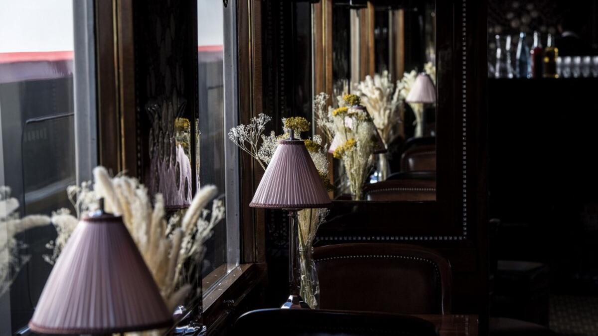 This picture taken on May 13, 2019 shows table lamps and flowers adorning the dining car of a restored carriage of an Orient Express train displayed at the Gare de l'Est train station in Paris.  Christophe ARCHAMBAULT / AFP
