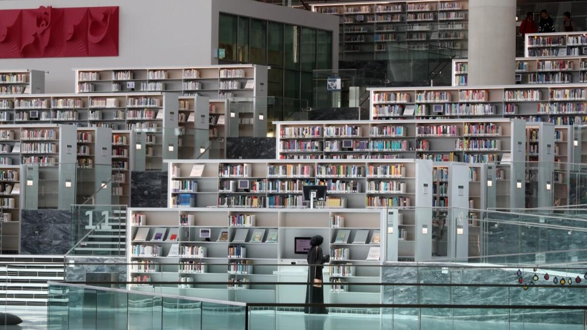 A woman chooses books at the Qatar National Library in the capital Doha.  KARIM JAAFAR / AFP