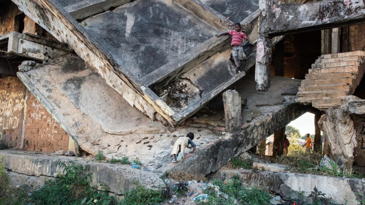 Children play on a derelict building, damaged during the Angolan civil war, in Kuito, Bie Province in central Angola. RODGER BOSCH / AFP