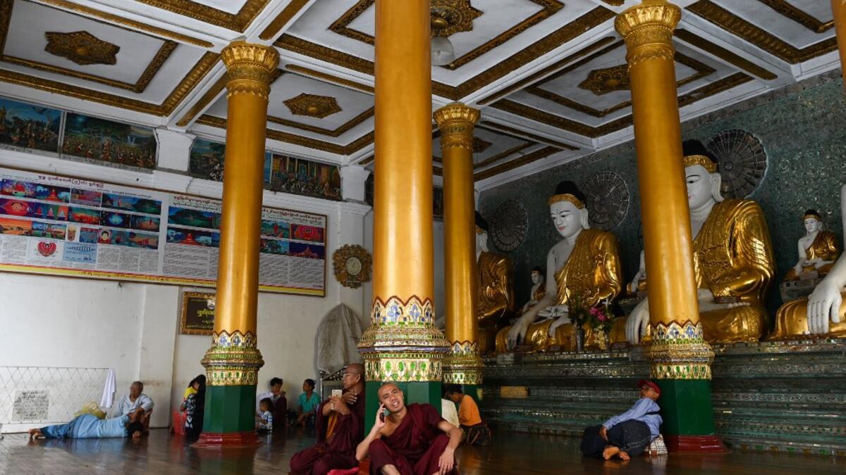 Buddhist monks and devotees rest in a temple at the Shwedagon pagoda in Yangon on June 14, 2019.  Ye Aung THU / AFP