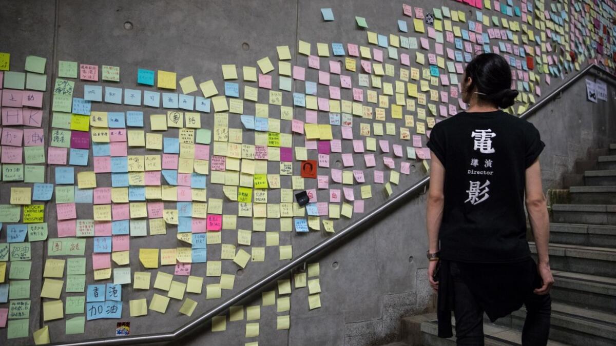A protester looks at messages left by demonstrators outside the government headquarters after a rally against a controversial extradition law proposal in Hong Kong .  DALE DE LA REY / AFP