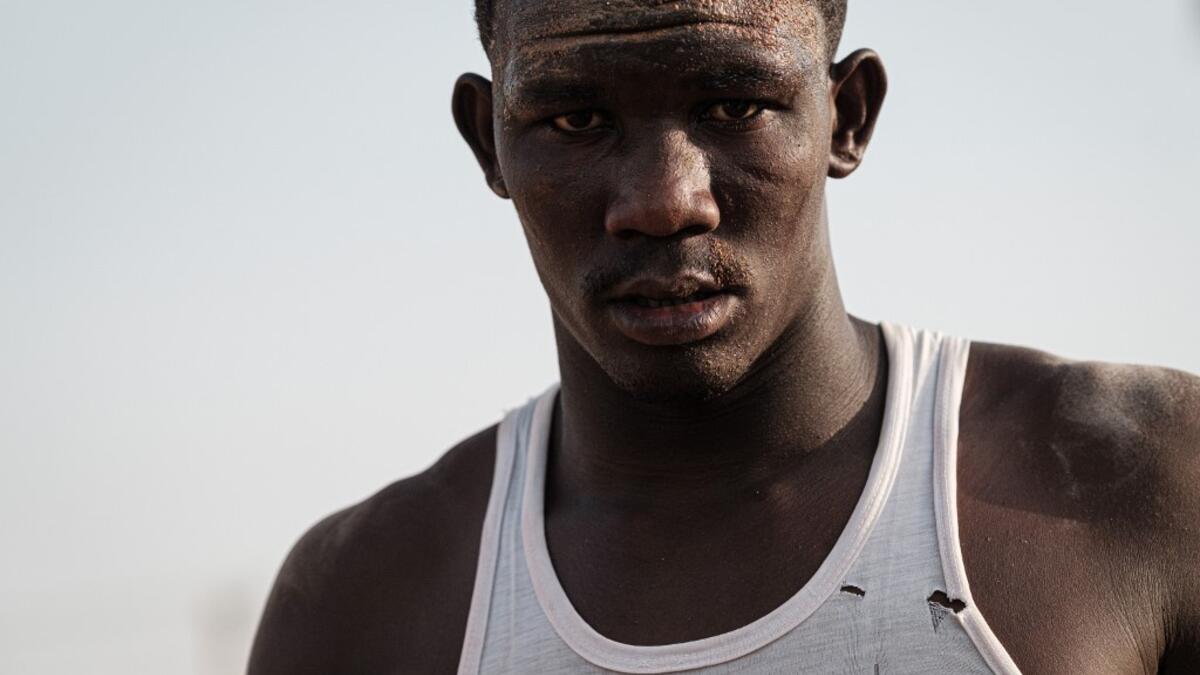 A Sudanese wrestler reacts during a traditional Nuba wrestling match at the Haj Youssef stadium in the district of Khartoum.  Yasuyoshi CHIBA / AFP