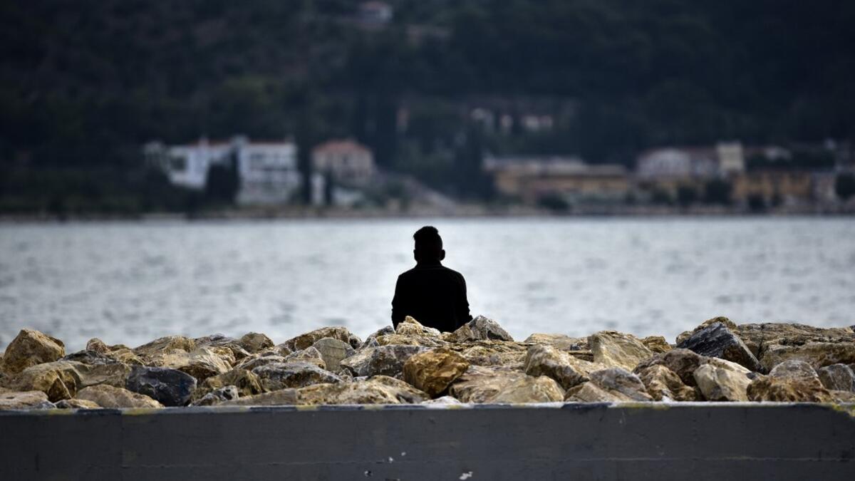 A migrant watches the sea at Samos' island capital city of Vathy.  LOUISA GOULIAMAKI / AFP