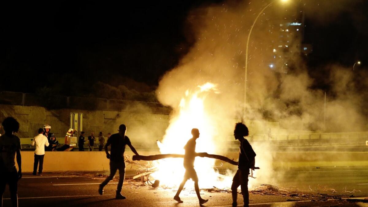 Israeli members of the Ethiopian community block a road in the coastal city of Netanya, to protest the killing of Solomon Tekah, a young man of Ethiopian origin who was killed by an off-duty police officer.  JACK GUEZ / AFP