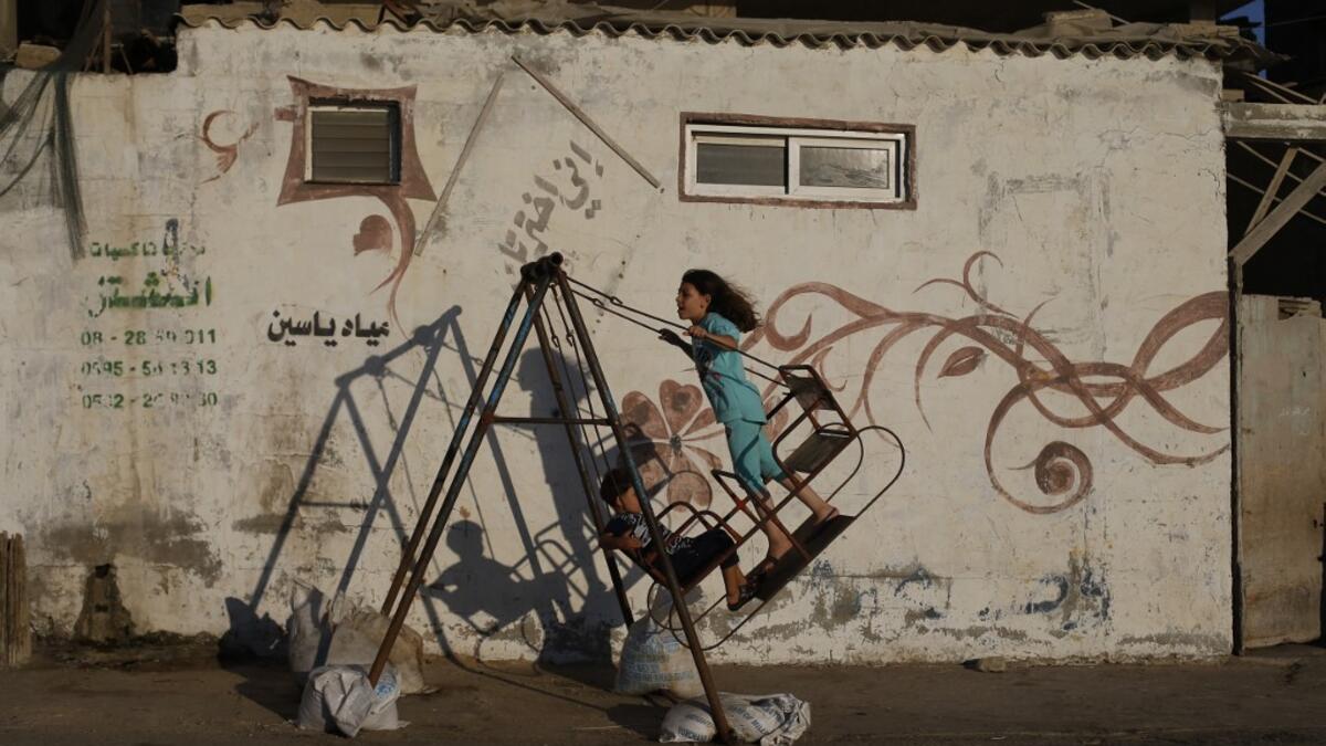 Palestinian children play on a swing at Al-Shatee Refugee Camp in Gaza City on July 3, 2019.  MOHAMMED ABED / AFP