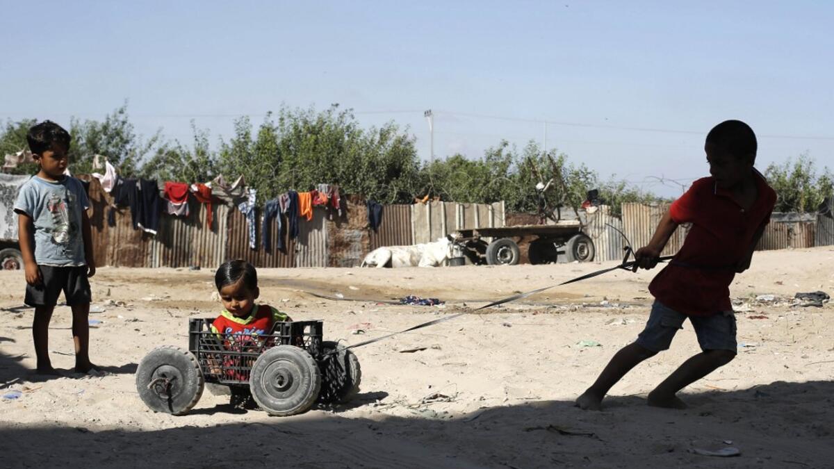 Palestinian children play at an impoverished neighbourhood in Gaza City on July 4, 2019.  MOHAMMED ABED / AFP