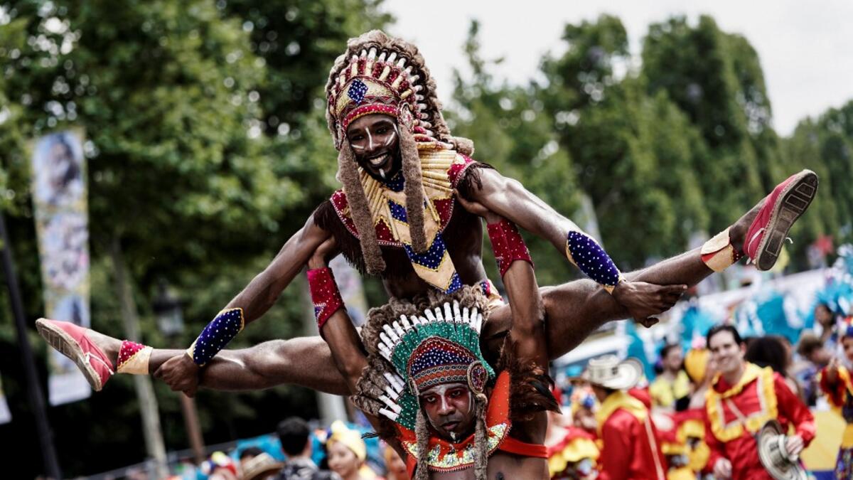 People parade during the Tropical Carnival on July, 7 2019 in Paris.  Kenzo TRIBOUILLARD / AFP