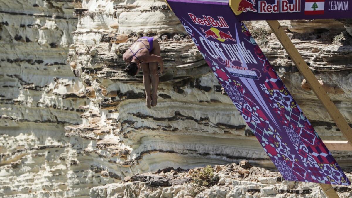 A cliff diver jumps from a platform on the landmark Raouche sea rock off the coast of the Lebanese capital Beirut on July 14, 2019, during the women's 2019 Red Bull Cliff Diving World Series.  ANWAR AMRO / AA / AFP