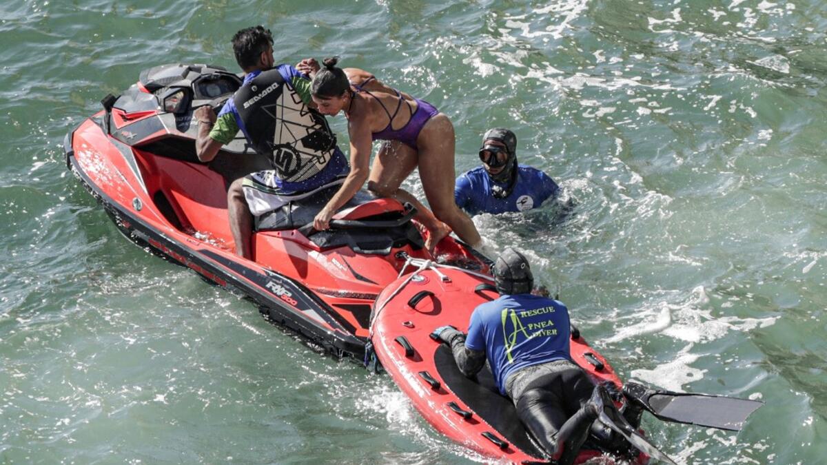 Rescuers assist a cliff diver after jumping off a platform on the landmark Raouche sea rock off the coast of the Lebanese capital Beirut on July 14, 2019, during the 2019 Red Bull Cliff Diving World Series.  ANWAR AMRO / AA / AFP
