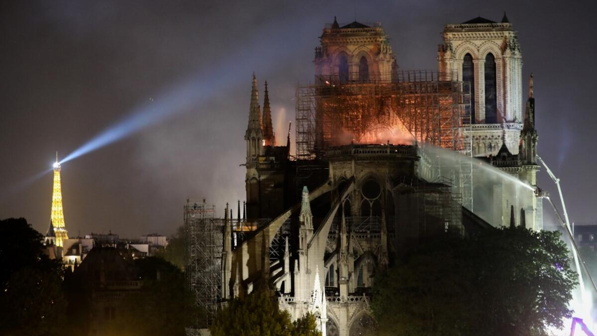 A fire fighter douses the flames during a fire at the Notre-Dame de Paris Cathedral on April 15, 2019, in the French capital Paris. STEPHANE DE SAKUTIN / AFP