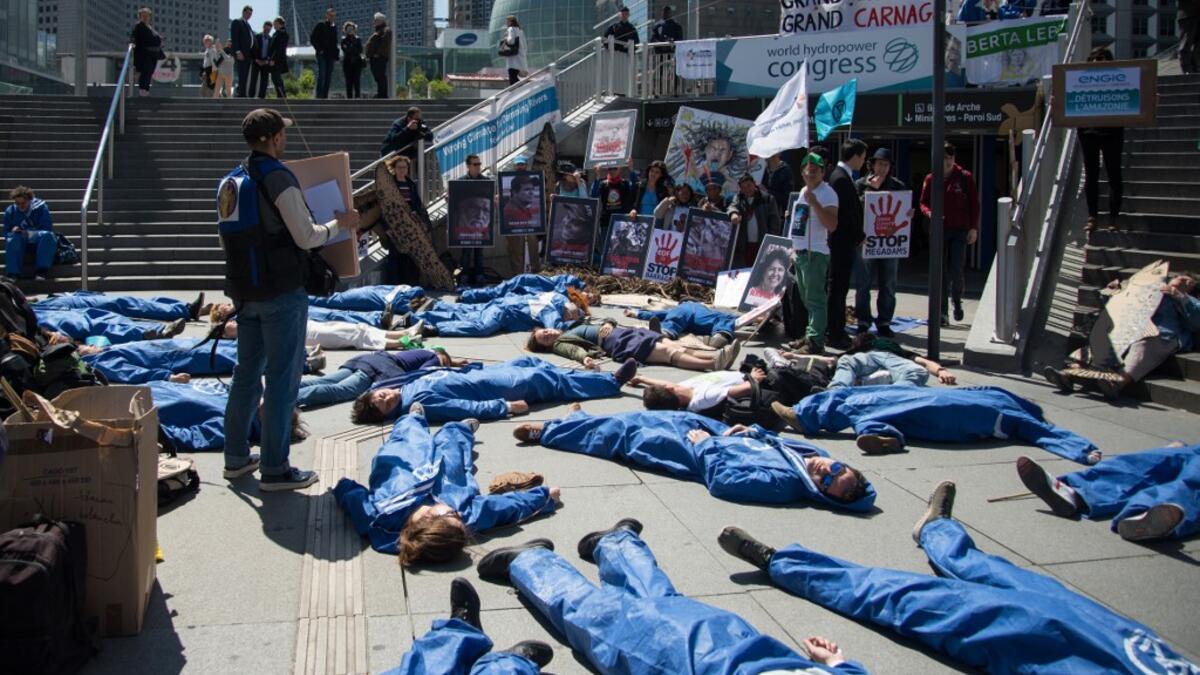 Activists of 'Extinction Rebellion' (XR) and NGO 'Planete Amazone' lie on the ground to stage an action called "die-in" to highlight the risk of the human race becoming extinct as a result of climate change, during a protest against large hydroelectric dams in front of the Grande Arche de La Defense, in Puteaux, northwest of Paris, on May 14, 2019. AFP