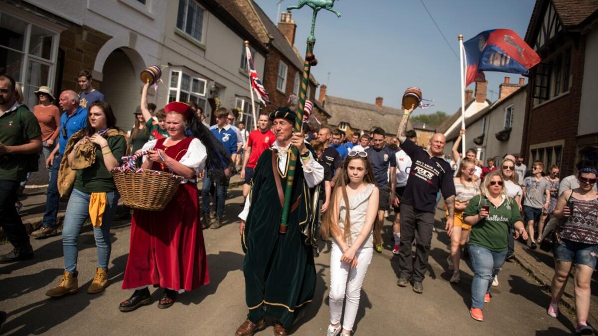 Teams from the villages of Hallaton and Medbourne process to the start point to fight over the 'bottles' (wooden casks) during the Easter Monday Hallaton Hare Pie Scrambling and Bottle Kicking traditional event in the village of Hallaton in central England on April 22, 2019.  Oli SCARFF / AFP