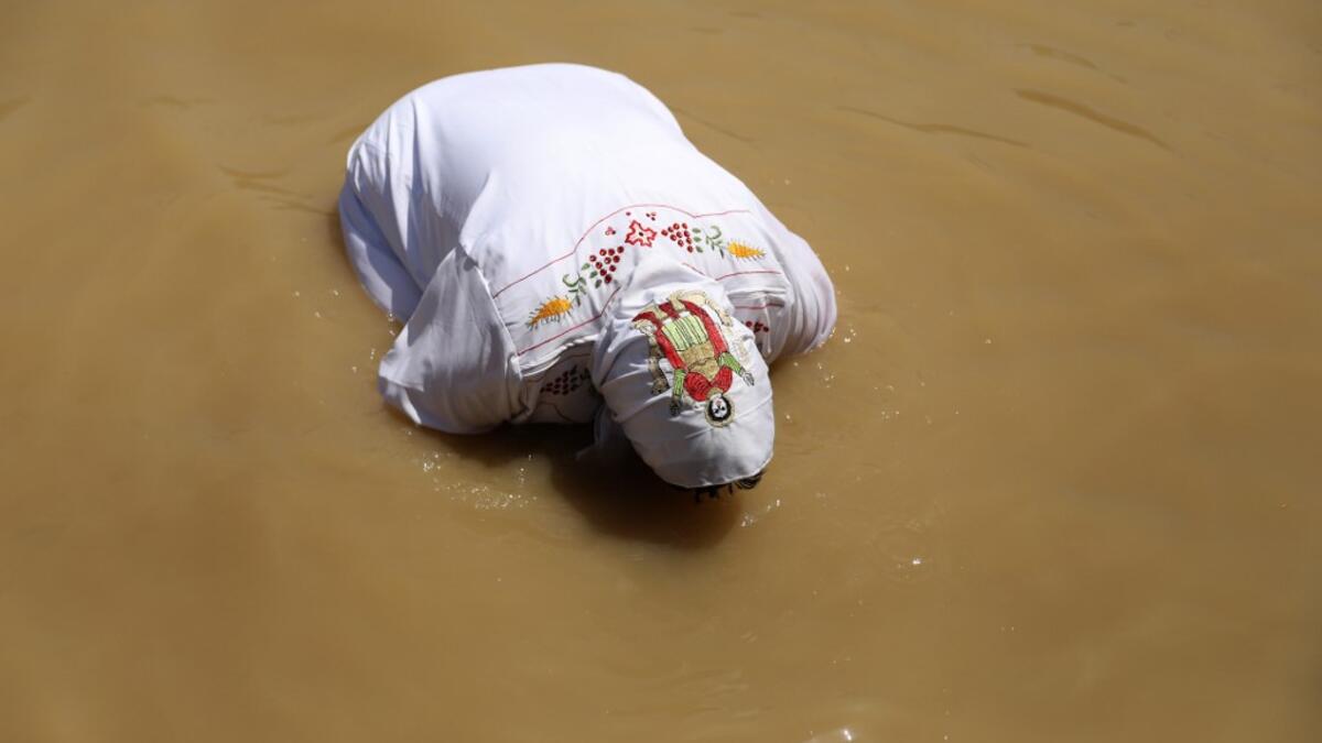 A Coptic Egyptian pilgrim submerges herself in the waters of the Jordan River after she was baptized on April 23, 2019 at the Qasr al-Yahud baptismal site near the West Bank city of Jericho as part of their Easter pilgrimage to the holy Land. According to the gospels Jesus Christ was baptized in the waters of the Jordan River by John the Baptist. GALI TIBBON / AFP