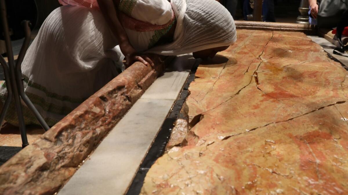 An Orthodox pilgrim kisses the anointment stone at the church of the Holy Sepulchre in Jerusalem's Old City, on April 25, 2019, during the Orthodox Holy Week.  GALI TIBBON / AFP