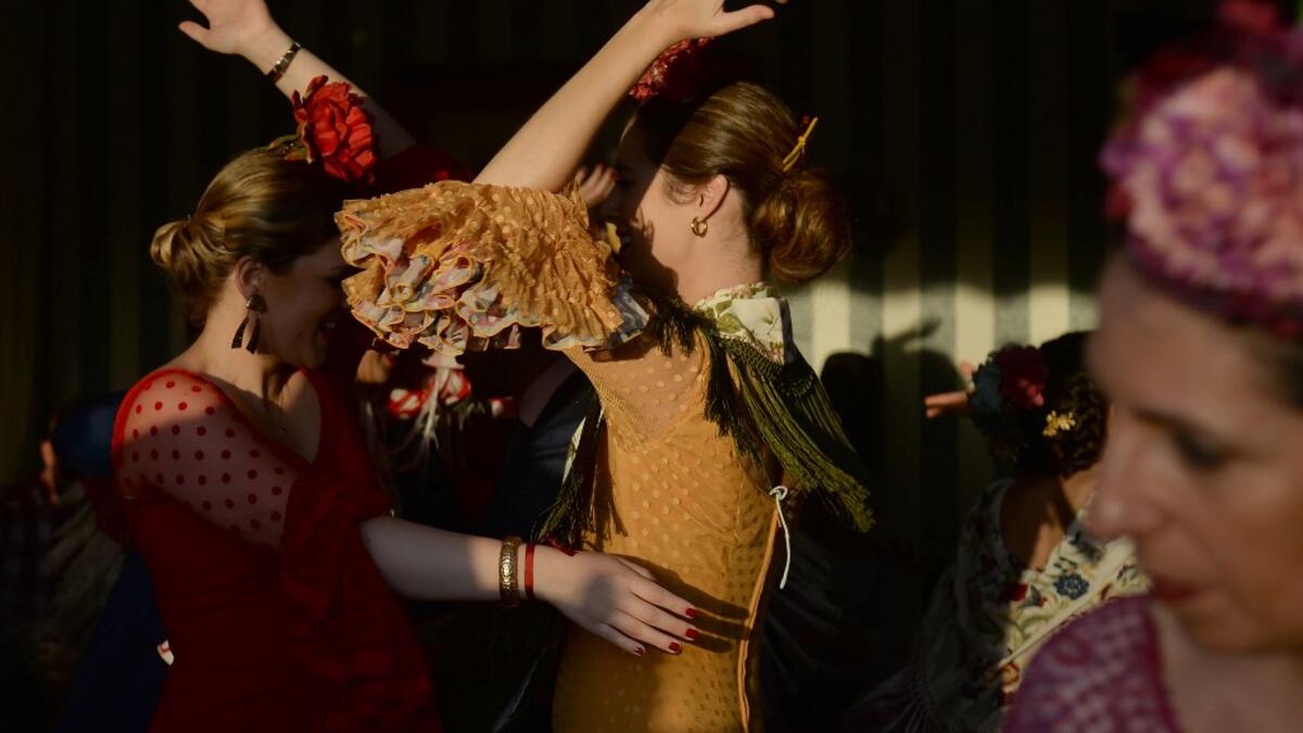 Women in traditional Sevillian dresses dance in a "caseta" (stall) during the "Feria de Abril" (April Fair) festival in Seville on May 6, 2019. CRISTINA QUICLER / AFP